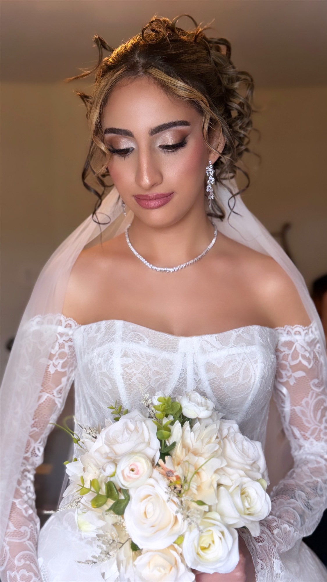 Close-up of finished bridal makeup, bride holding her bouquet